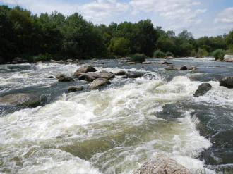 Между глыбами с большой скоростью, шумом и клекотом течет вода